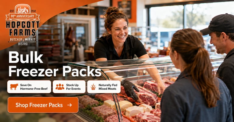 Butcher at counter showing bulk freezer meat packs to customers at Hippolit Farms store