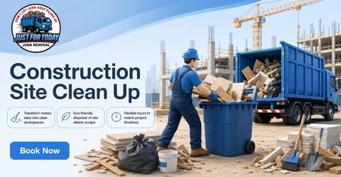 Worker in hard hat loading debris into blue dumpster at construction site with crane and building framework in background